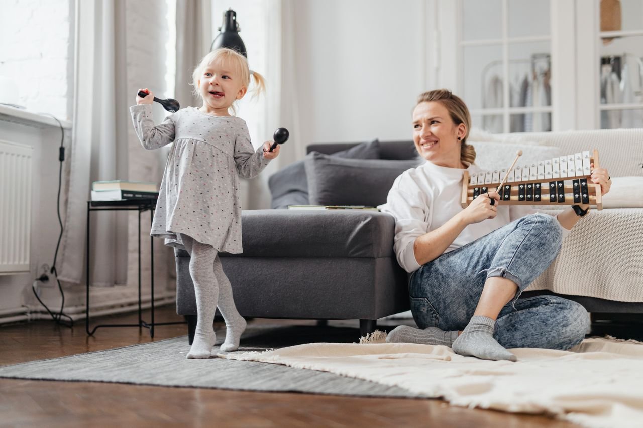 Crafting Captivating Headlines: Your awesome post title goes here A joyful moment of a mother and daughter playing maracas and xylophone indoors.