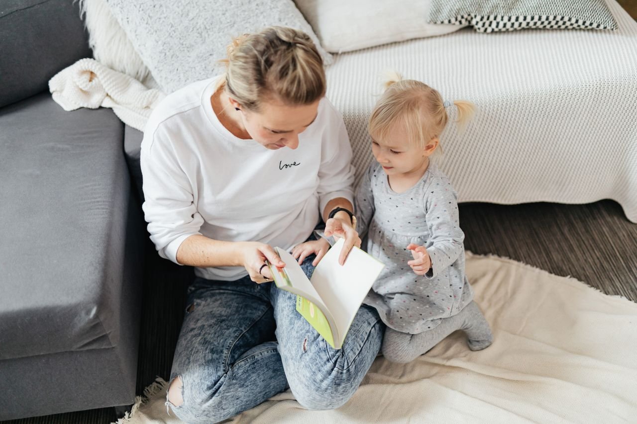 The Art of Drawing Readers In: Your attractive post title goes here Mother and daughter bonding over a book in a cozy living room setting.
